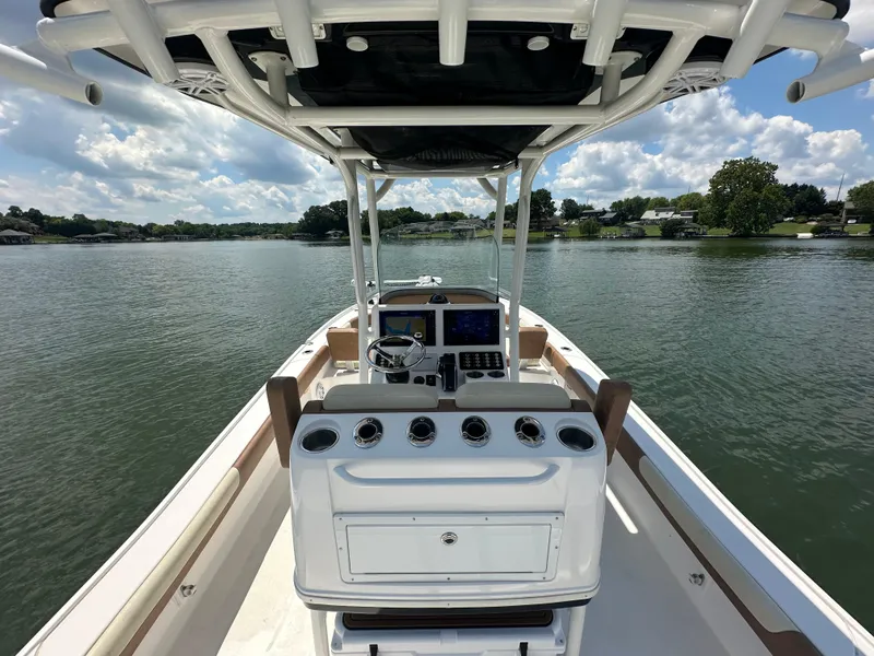 Slide: The Image of 2023 Caymas 26 HB boat on a serene lake under a partly cloudy sky. - 20