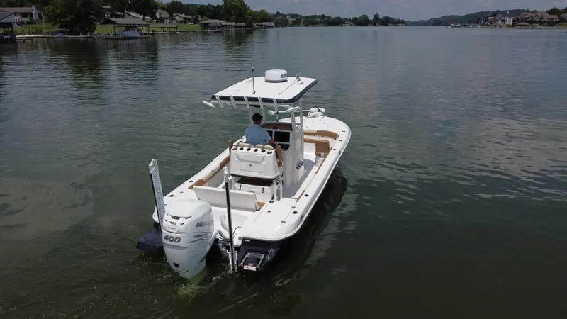 Slide: The Image of 2023 Caymas 26 HB boat cruising on a calm lake with scenic shoreline. - 4