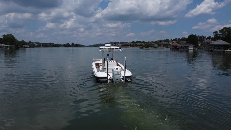 Slide: The Image of 2023 Caymas 26 HB boat cruising on a serene lake under a partly cloudy sky. - 5