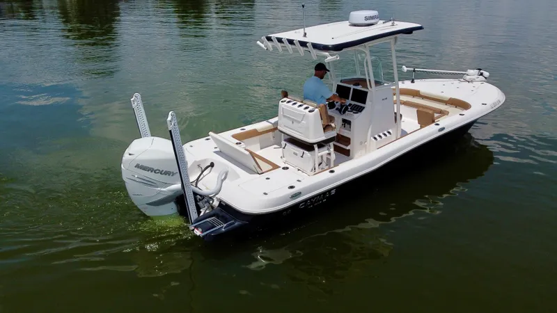Slide: The Image of 2023 Caymas 26 HB boat on calm water, featuring Mercury outboard engine. - 7