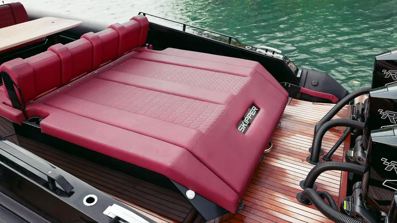 Slide: The Image of Luxurious red seating on 2025 Skipper-BSK 42NC boat, docked by the water. - 17