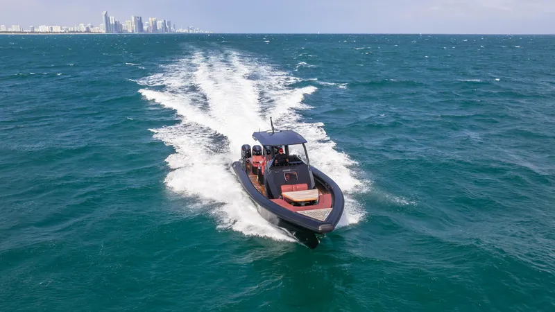 Slide: The Image of 2025 Skipper-BSK 42NC speedboat cruising on open sea with city skyline in background. - 4