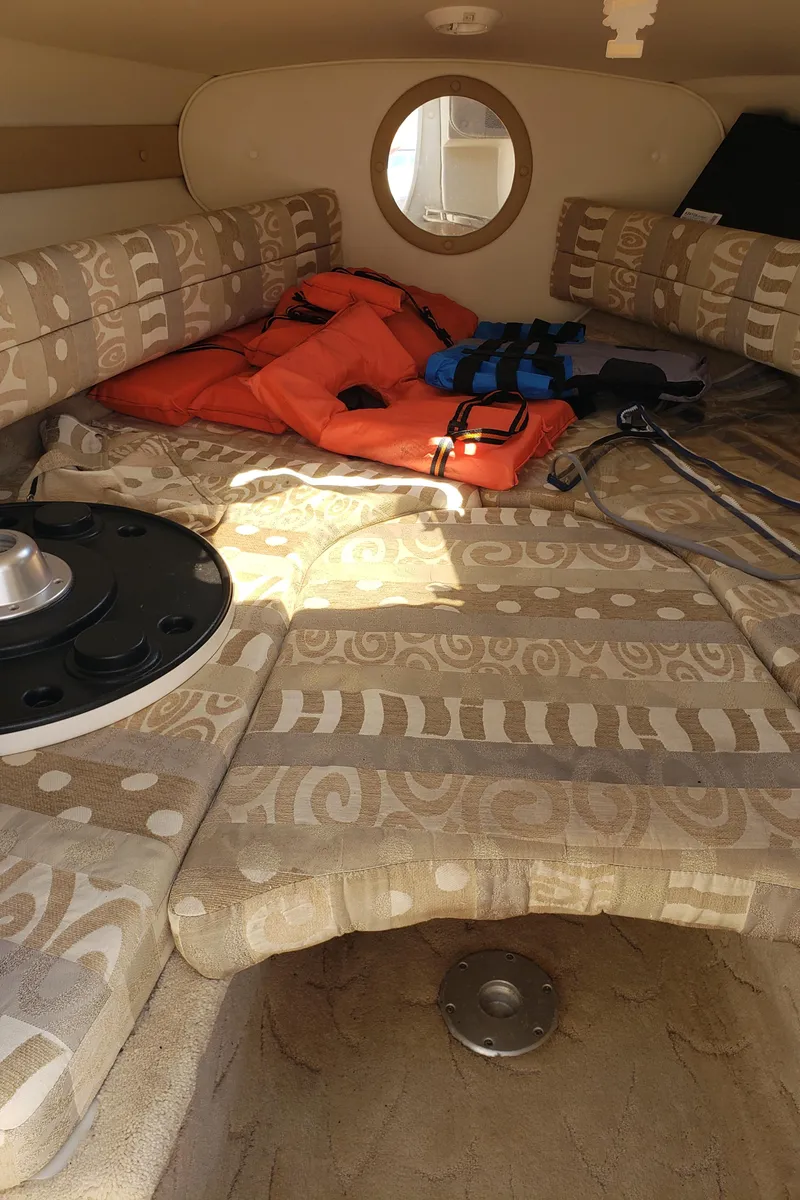 Slide: The Image of 2005 Rinker 232 Captiva Cuddy cabin interior with life jackets and patterned cushions. - 10