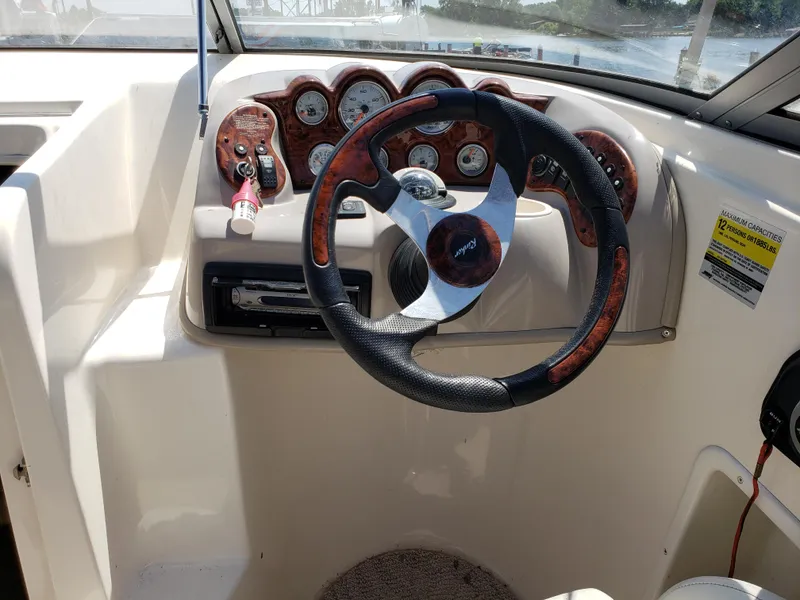 Slide: The Image of 2005 Rinker 232 Captiva Cuddy dashboard with steering wheel and gauges. - 4