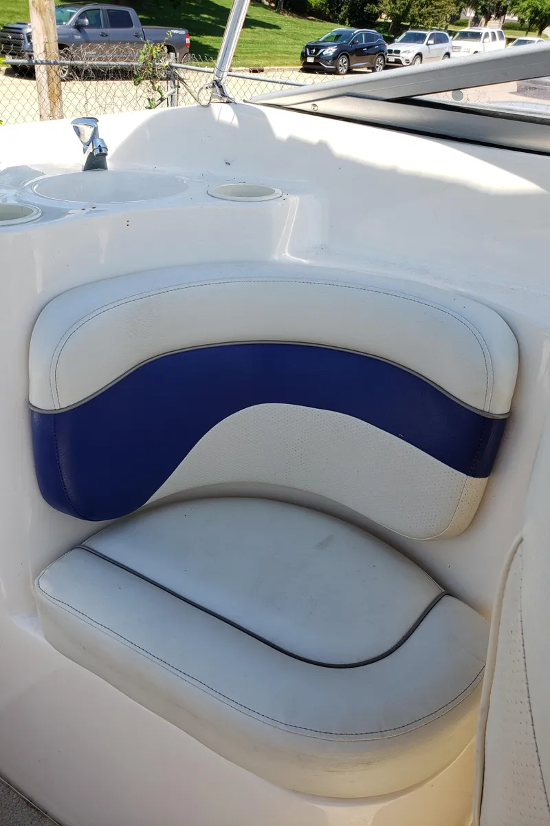Slide: The Image of 2005 Rinker 232 Captiva Cuddy boat interior with blue and white seating. - 7