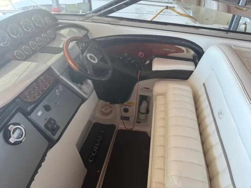 Slide: The Image of Interior of a 2001 Cobalt 360 boat with white seating and control panel. - 13