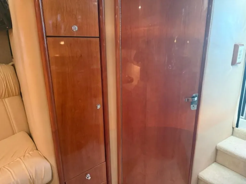 Slide: The Image of Interior of 2001 Cobalt 360 boat with wooden cabinetry and beige seating. - 18