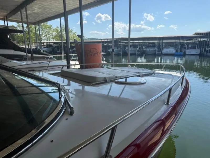 Slide: The Image of 2001 Cobalt 360 boat docked in a marina under a covered area, with clear skies. - 8