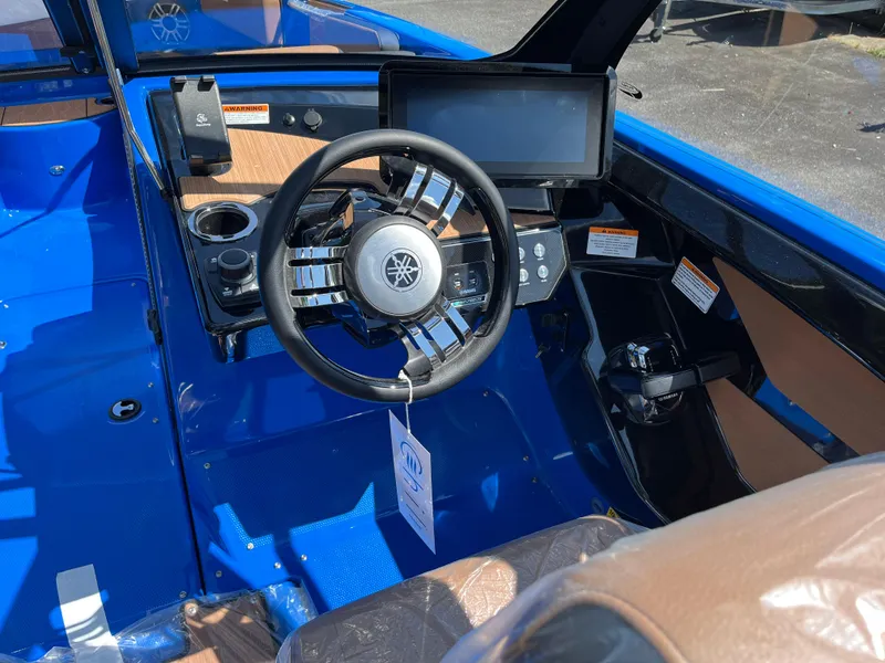 Slide: The Image of 2025 Yamaha Boats 222XD cockpit with steering wheel, touchscreen, and blue interior. - 2