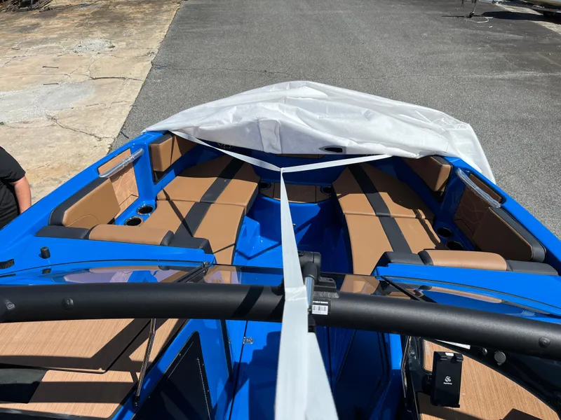 Slide: The Image of 2025 Yamaha Boats 222XD with blue exterior and tan seating, docked on pavement. - 6