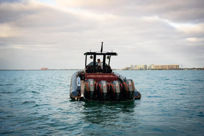 Slide: The Image of Skipper-BSK 42NC 2025 boat with multiple engines on open water under cloudy sky. - 9