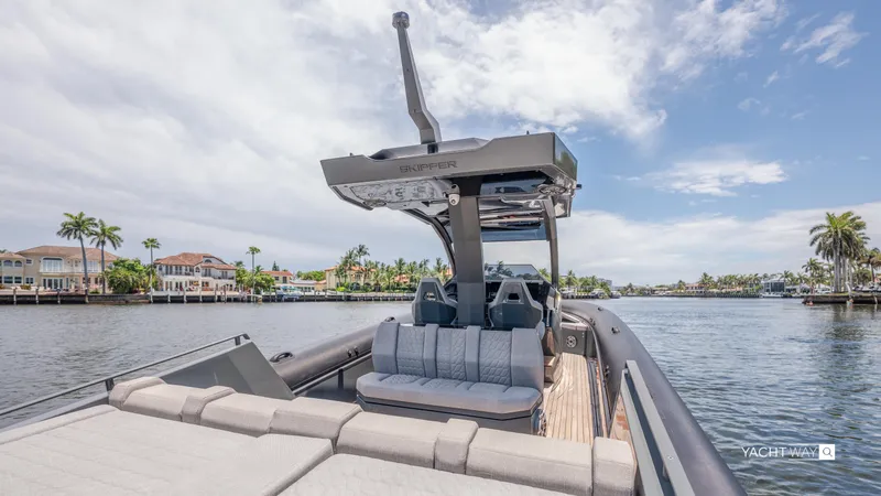 Slide: The Image of 2025 Skipper-BSK 38NC luxury boat on a scenic waterfront with palm trees. - 14