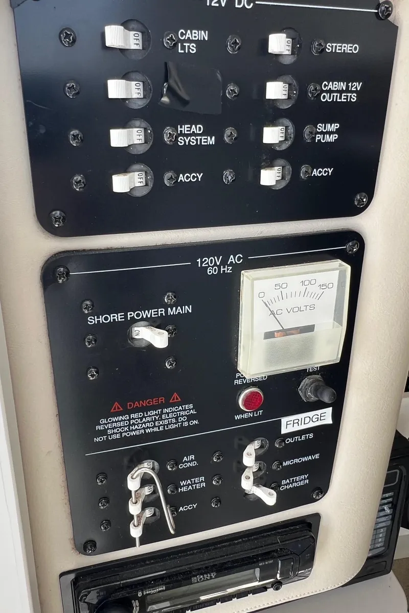 Slide: The Image of 2003 Hydra-Sports Vector 2800 WA control panel with switches and voltage meter. - 12
