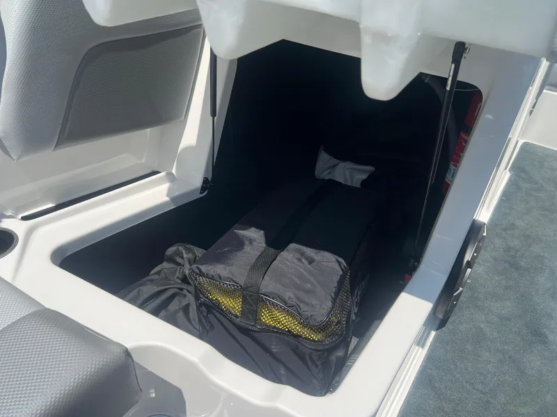 Slide: The Image of Storage compartment in a 2020 MasterCraft NXT20 boat with gear bag inside. - 13
