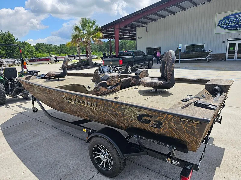 Slide: The Image of 2026 G3 Sportsman 1710 boat with camouflage design parked outside a dealership. - 2