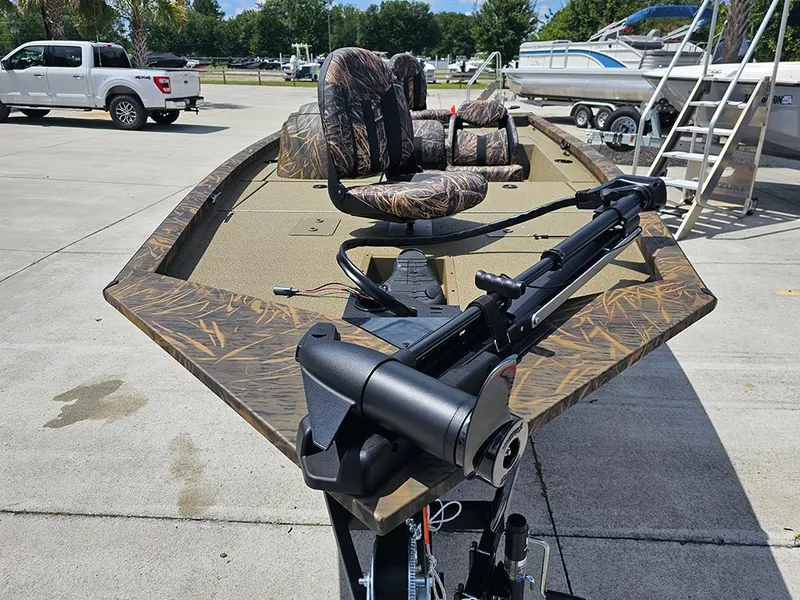 Slide: The Image of 2026 G3 Sportsman 1710 boat with camo seats and trolling motor in a parking lot. - 3