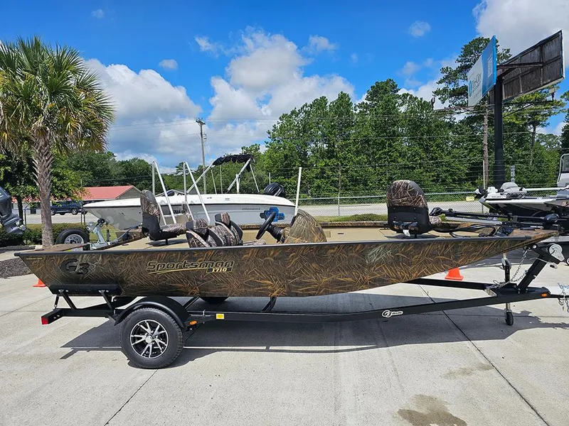 Slide: The Image of 2026 G3 Sportsman 1710 boat on trailer, camo design, parked outdoors under blue sky. - 5