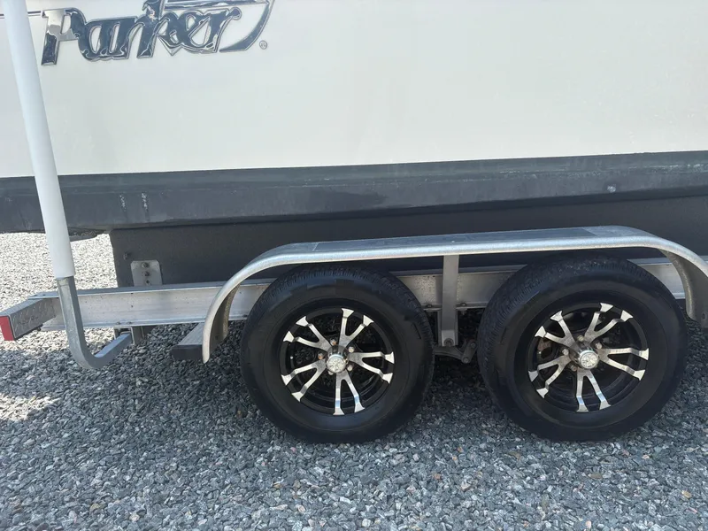 Slide: The Image of Trailer with dual wheels for 2021 Parker 2300 Special Edition boat on gravel. - 10