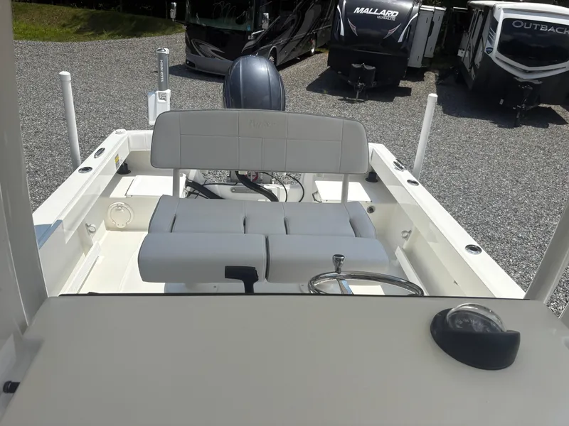 Slide: The Image of 2021 Parker 2300 Special Edition boat interior with seating and steering wheel, parked near RVs. - 11