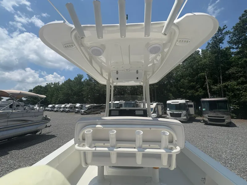 Slide: The Image of 2021 Parker 2300 Special Edition boat with rod holders, parked outdoors under a blue sky. - 15