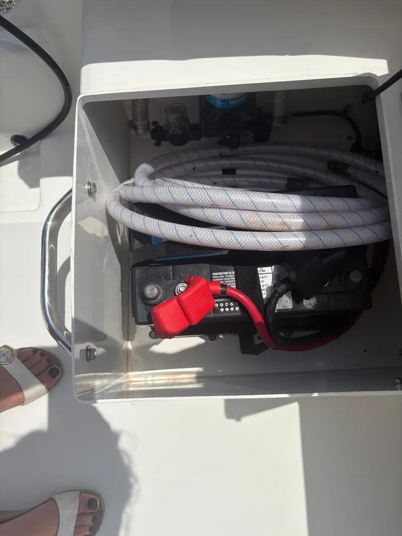 Slide: The Image of Battery compartment of a 2021 Parker 2300 Special Edition boat with coiled hose. - 26