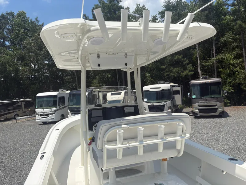 Slide: The Image of 2021 Parker 2300 Special Edition boat with T-top, parked near RVs in a wooded area. - 6
