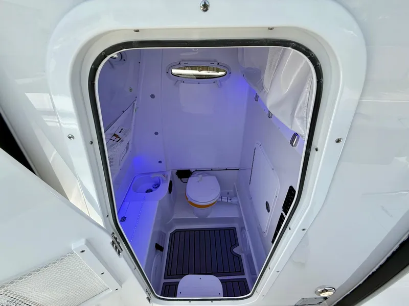 Slide: The Image of Interior of 2026 Sea Hunt Gamefish 28 Coffin Box boat, featuring a compact marine toilet. - 15