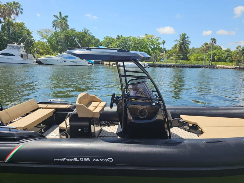 The Image of 2023 Ranieri CAYMAN 26 SPORT TOURING boat docked by the water, with luxury seating and canopy. - 0