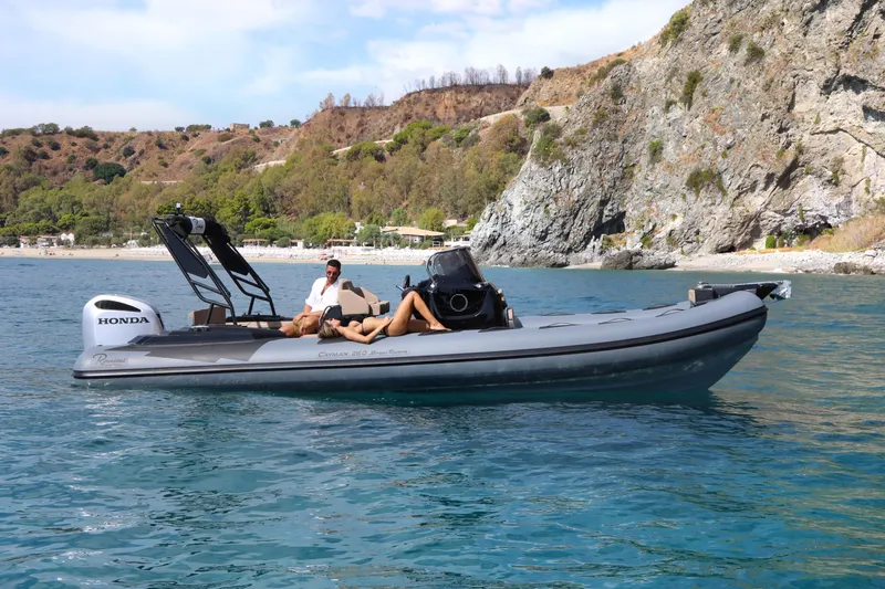 Slide: The Image of 2023 Ranieri CAYMAN 26 SPORT TOURING boat cruising near rocky coastline. - 13