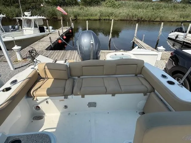 Slide: The Image of 2020 NauticStar 2302 Legacy Dual Console boat with tan seating at a dock. - 10