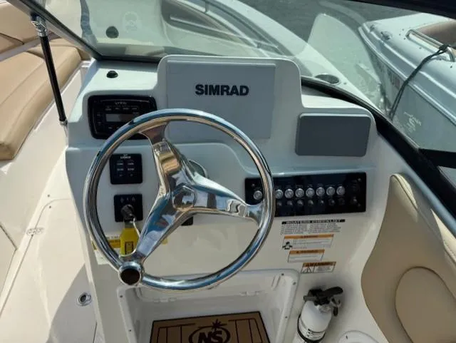 Slide: The Image of 2020 NauticStar 2302 Legacy Dual Console boat dashboard with Simrad display and steering wheel. - 13