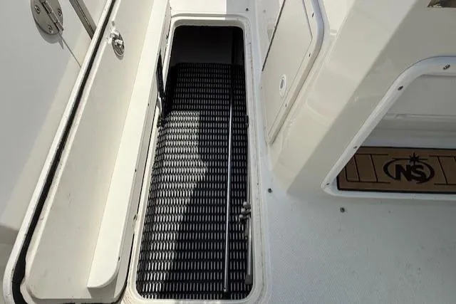 Slide: The Image of 2020 NauticStar 2302 Legacy Dual Console boat storage compartment with black mat. - 18