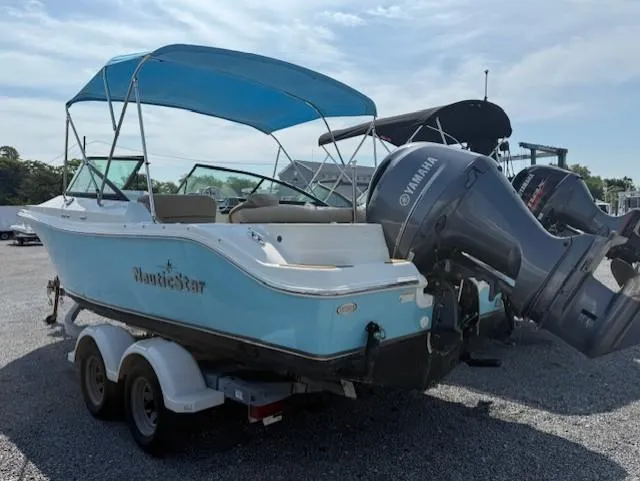 Slide: The Image of 2020 NauticStar 2302 Legacy Dual Console boat with Yamaha outboard engine on trailer. - 2