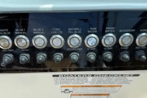 Slide: The Image of Control panel of 2020 NauticStar 2302 Legacy Dual Console boat with labeled switches. - 21