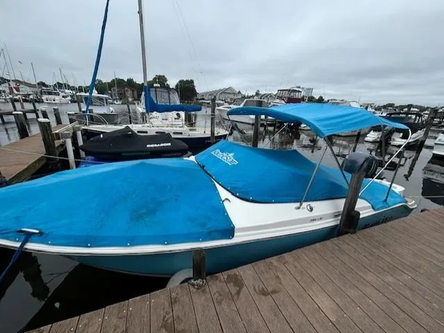 Slide: The Image of 2020 NauticStar 2302 Legacy Dual Console boat docked with blue cover. - 24