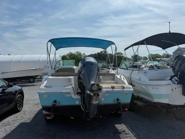 Slide: The Image of 2020 NauticStar 2302 Legacy Dual Console boat with blue canopy, parked on gravel. - 3