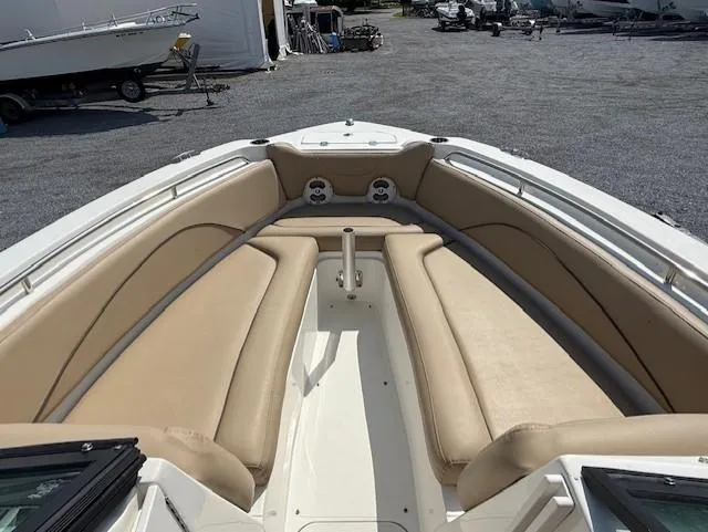 Slide: The Image of 2020 NauticStar 2302 Legacy Dual Console boat with beige seating in a marina setting. - 5