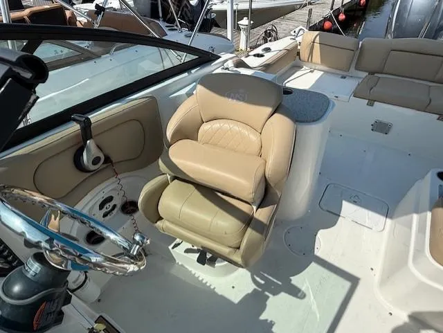 Slide: The Image of 2020 NauticStar 2302 Legacy Dual Console interior with beige seating and steering wheel. - 7