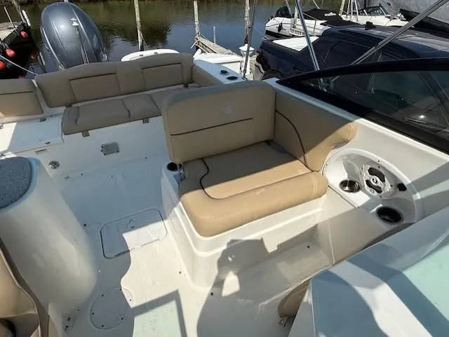 Slide: The Image of 2020 NauticStar 2302 Legacy Dual Console boat interior with beige seating and cup holders. - 8