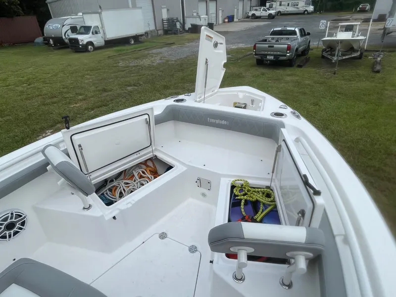 Slide: The Image of 2023 Everglades 235 Center Console boat with open storage compartments and visible ropes. - 14