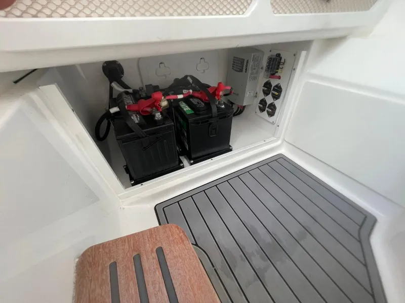 Slide: The Image of Battery compartment of 2023 Everglades 235 Center Console boat, featuring dual batteries and control panel. - 17