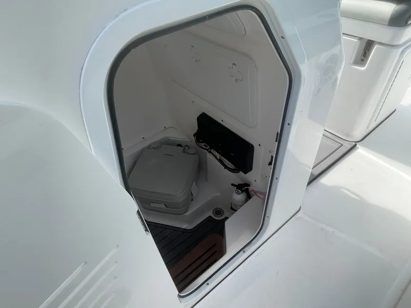 Slide: The Image of 2023 Everglades 235 Center Console boat interior storage compartment with portable toilet. - 19
