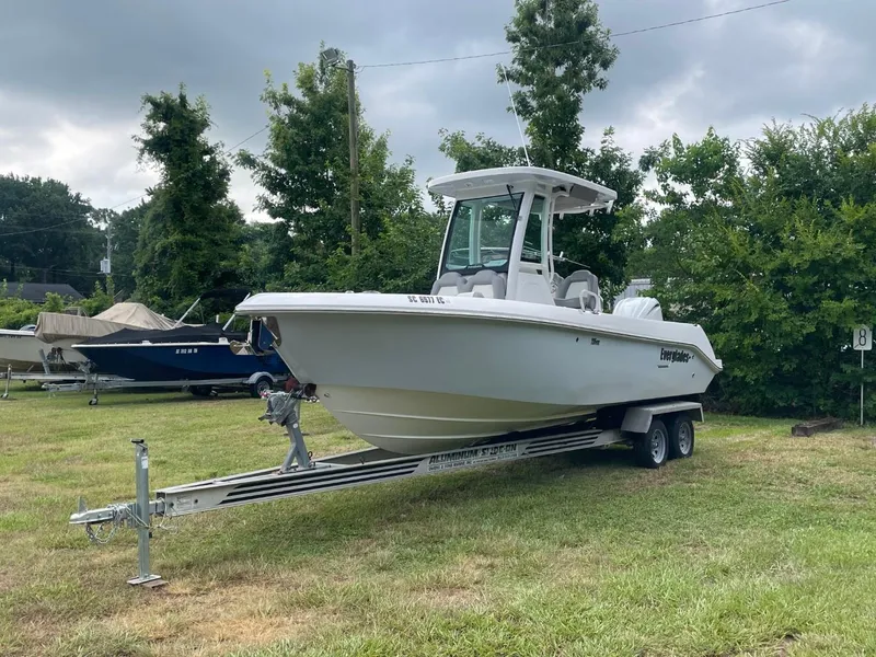 Slide: The Image of 2023 Everglades 235 Center Console boat on trailer, parked on grass. - 2