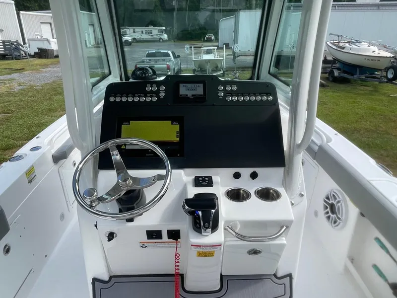 Slide: The Image of 2023 Everglades 235 Center Console boat dashboard with steering wheel and controls. - 22