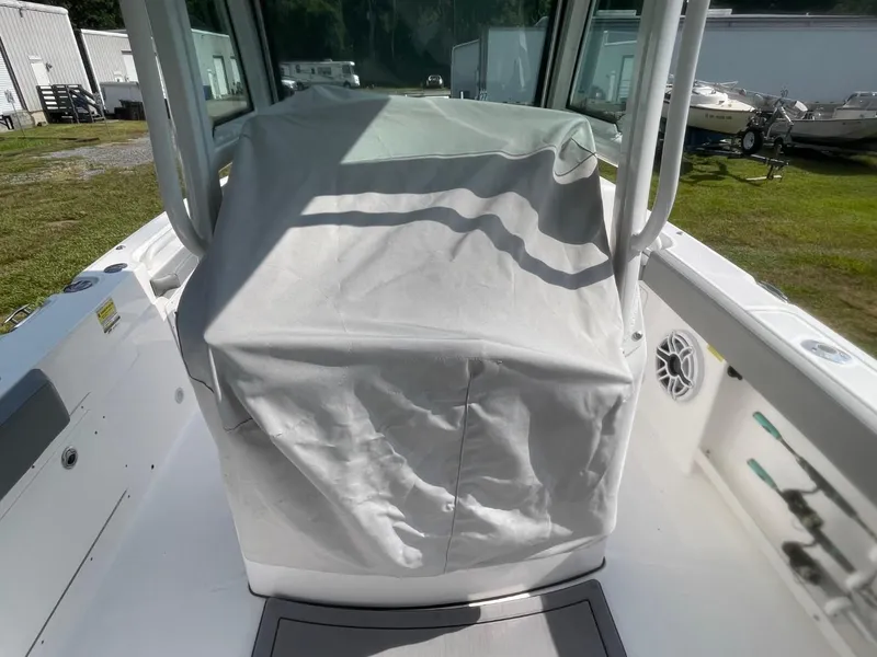 Slide: The Image of 2023 Everglades 235 Center Console boat with covered console, parked outdoors. - 23