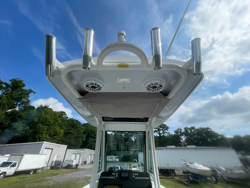 Slide: The Image of 2023 Everglades 235 Center Console boat with rod holders and speakers under a clear sky. - 29