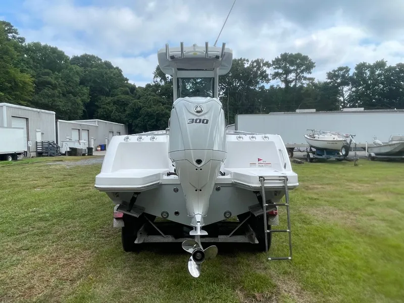 Slide: The Image of 2023 Everglades 235 Center Console boat with powerful outboard motor, parked on grass. - 5