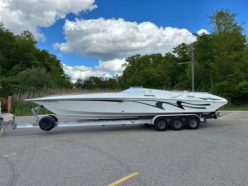 Slide: The Image of 1994 Fountain 35 Lightning speedboat on trailer, parked outdoors under a cloudy sky. - 1