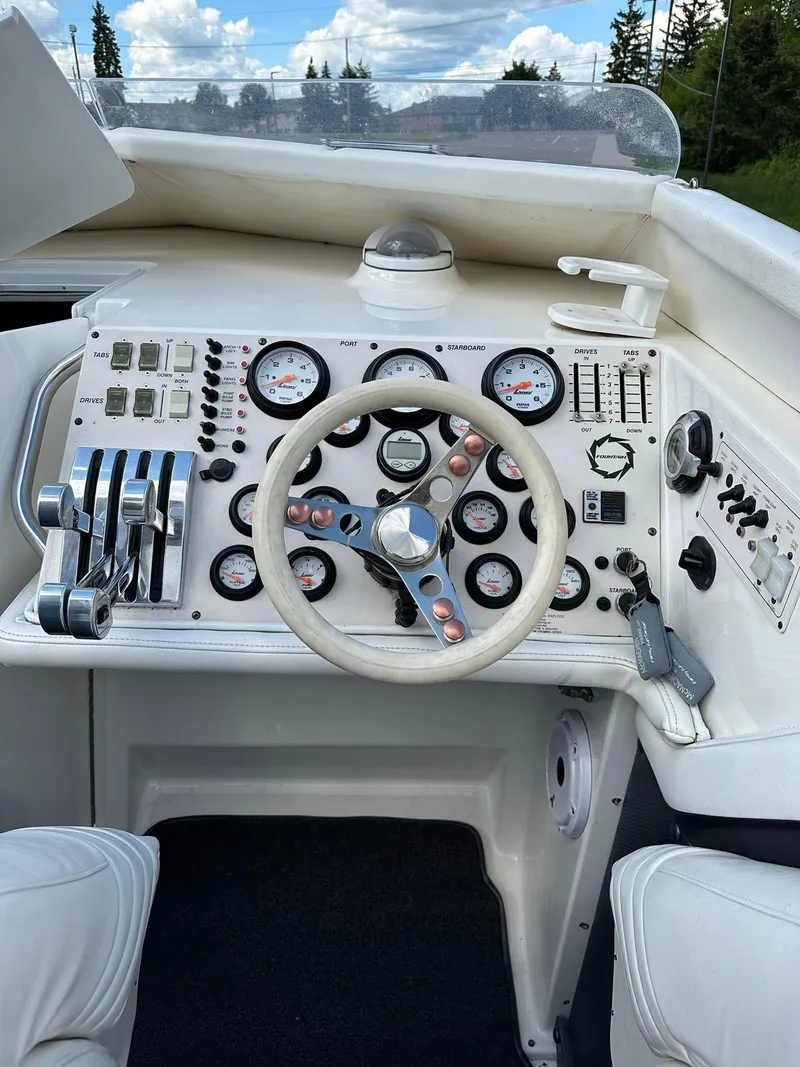 Slide: The Image of 1994 Fountain 35 Lightning boat dashboard with gauges, steering wheel, and controls. - 13
