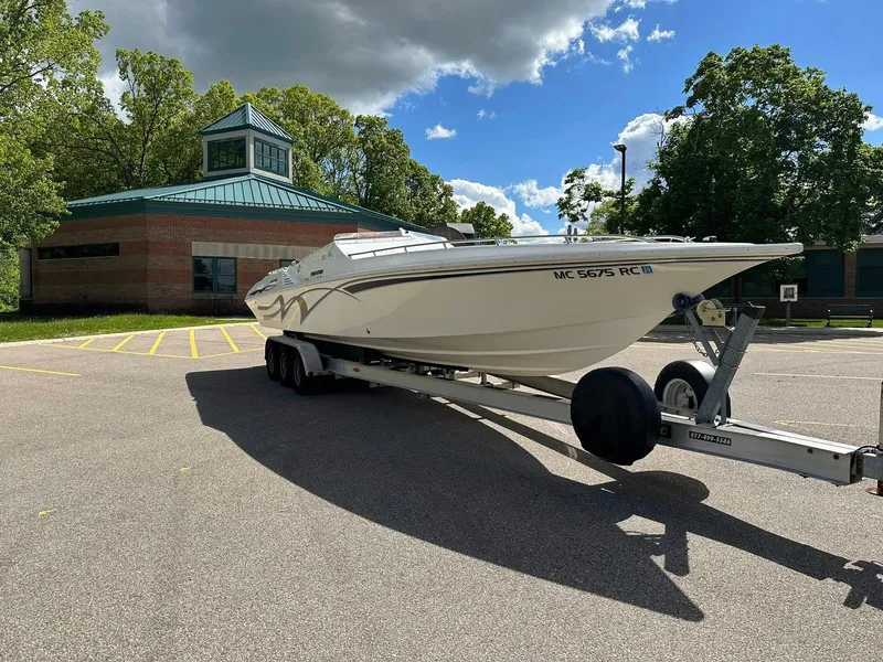 Slide: The Image of 1994 Fountain 35 Lightning boat on trailer in parking lot, sunny day, trees and building in background. - 2